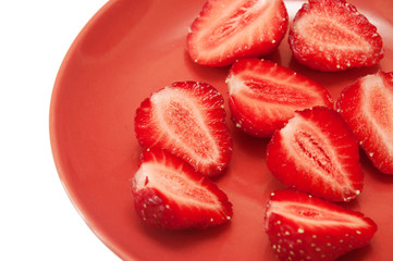 sliced strawberries on a red saucer