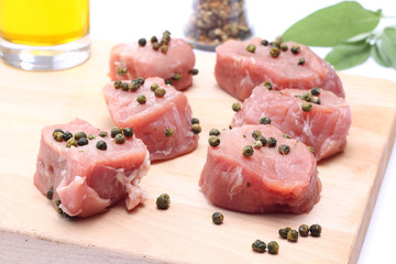 Raw pork fillet with green pepper on wooden cutting board
