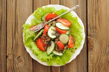 Lentil salad with tomatoes, cucumbers, capers and lettuce with t