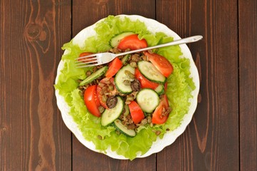Lentil salad with tomatoes, cucumbers, capers and lettuce with t