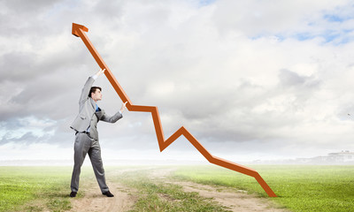 Businessman making graph arrow grow