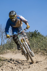 Fototapeta na wymiar Downhill competition, Biker rides fast in the countryside.