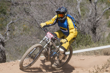 Fototapeta premium Downhill competition, Biker rides fast in the countryside.