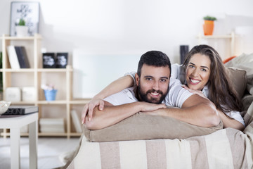 happy couple on bed sofa in living room