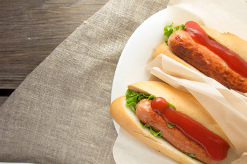 Hotdogs on white dish  wooden table