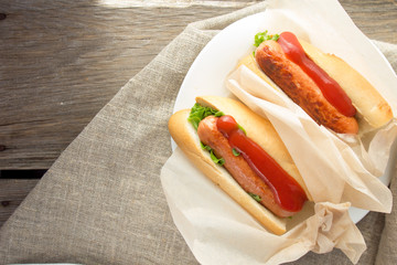 Hotdogs on white dish  wooden table