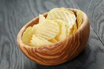 rippled organic chips in wood bowl on wooden table
