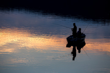 small fishermen ship on a sundown lake