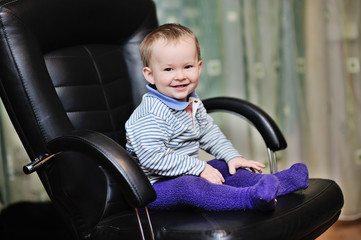 baby boy sitting in a leather office chair