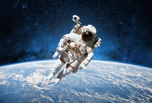 Astronaut in outer space with planet earth as backdrop. Elements