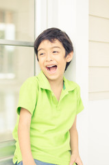 Little boy sitting at the window with happy face