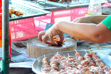People cooking chicken fried in soft light