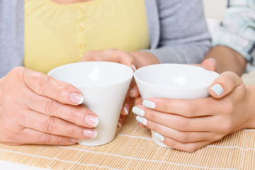 Close up of cups held by women