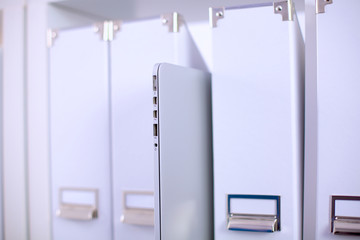File folders, standing on  shelves in the background