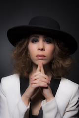 Elegant young lady wearing a black hat