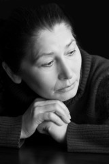 Mature woman in deep sitting  thought  at home.