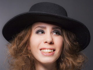Elegant young lady wearing a black hat