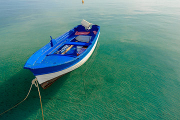 Azure blue motor boat floating on calm transparent sea water on Greek Kos island