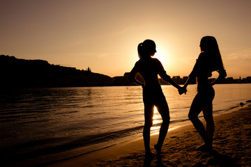 Fototapeta na wymiar silhouettes of girlfriends at sunset