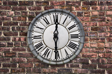Vintage retro style clock on a red brick wall