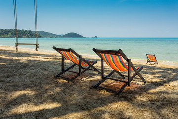sun beach chairs on shore near sea.