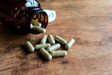 Herb capsule spilling out of bottle