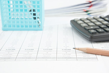 Pencil and calculator on finance account with stack old paperwork