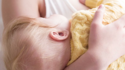 Little sleeping baby on hands of mother