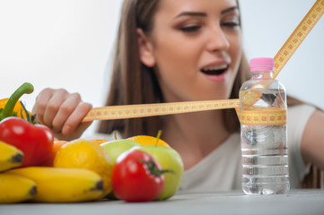 Beautiful girl is sitting at the table with healthy food