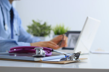 Male doctor using a laptop, sitting at his desk