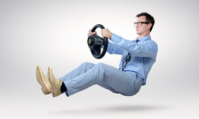 Businessman driver in glasses and tie with a wheel