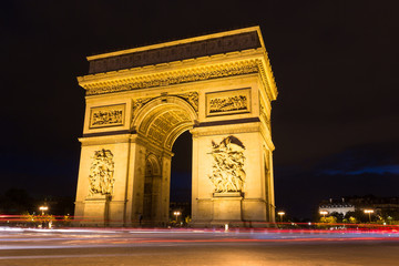 Fototapeta na wymiar Illuminated Arc de Triomphe with light rails of passing traffic in Paris