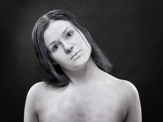 Kobieta pomalowana na biało na ciemnym tle