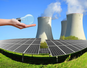 Solar energy panels with nuclear power plant and bulb in hand. 