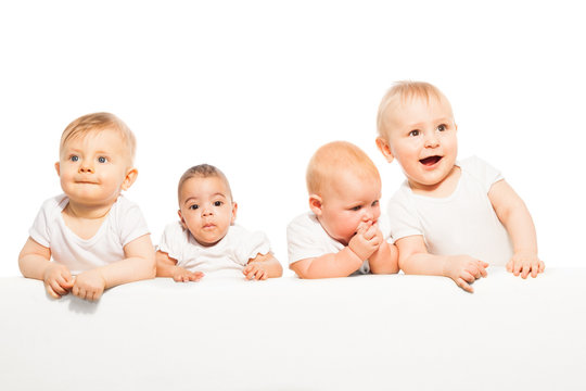 Cute babies stand in a row on the white background