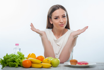 Beautiful young girl is choosing between healthy and unhealthy