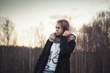 Caucasian teenage girl in a spring forest, sepia filter