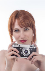 Portrait of young woman taking a photo using an old camera