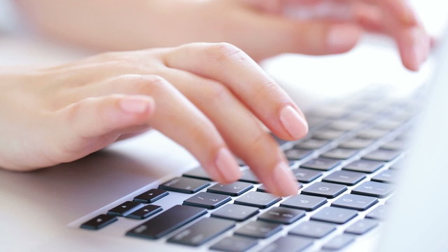 Womans hands typing on the laptop keyboard