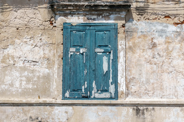 old window in blue color on dirty wall