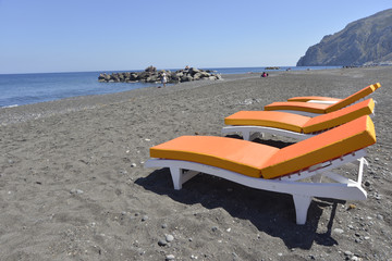 Fototapeta na wymiar beds on beach Kamari Santorini, Greece