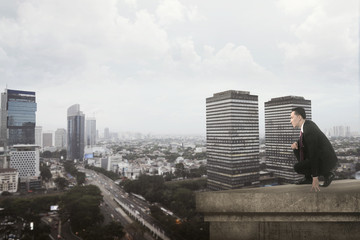 Fototapeta na wymiar Asian Man Watching Something On The Rooftop