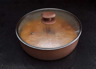 Chicken and potato pie  in casserole against black marble background © yarlander