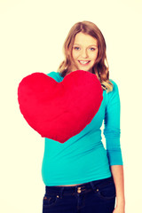 Young woman with heart shaped pillow