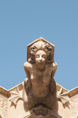 Fototapeta na wymiar Ornamental sculpture of a mermaid on the roof of a Baroque palace in Lentini, Sicily