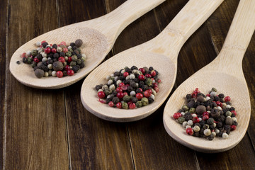 a mixture of pepper in wooden spoon