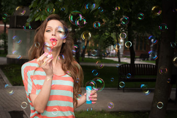 woman have fun with soap bubbles in summer park