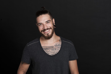 Attraktiver junger Mann mit tattoo und Bart lächelt