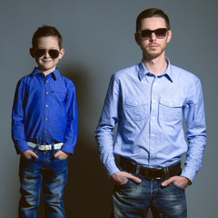 Two gentlemen: young father and his little cute son in sunglasse