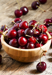 Fresh cherries in a wooden bowl, selective focus
